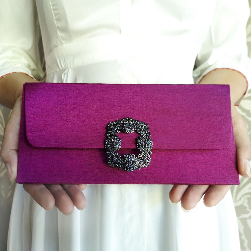 Brooch embellished silk clutch