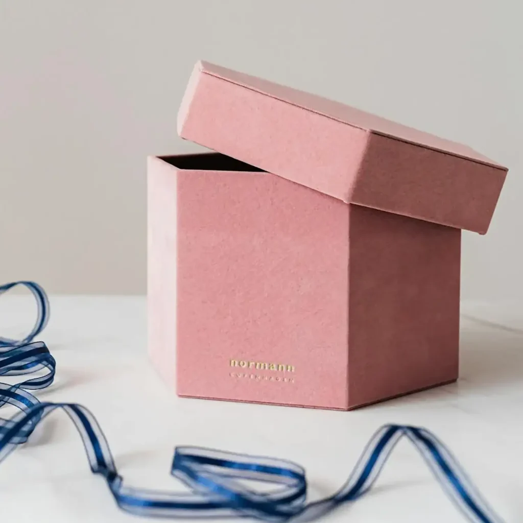 Dusty rose hexagon shaped suede gift box with gold foil stamped logo