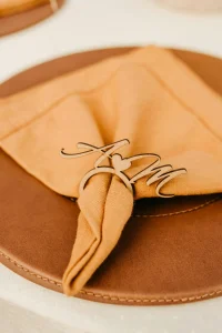 Close-up picture of laser cut monogram napkin ring made out of pine wood